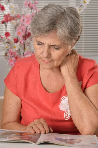 Middle-aged woman reading magazine — Stock Photo, Image