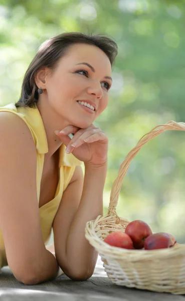 Woman with a basket of fruits — Stock Photo, Image