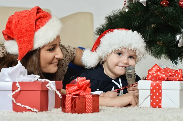 Mor med pojke nära julgran — Stockfoto