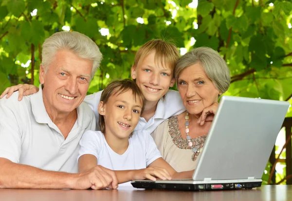 Familie met laptop in de natuur — Stockfoto