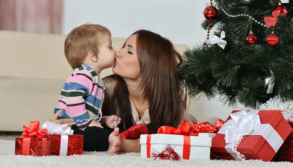 Mor og liten gutt nær juletreet – stockfoto