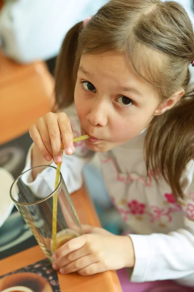 Niña bebiendo jugo en la cafetería — Foto de Stock