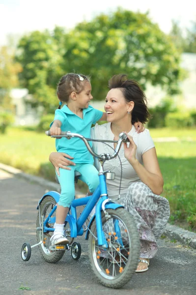 Girl on a bicycle with  mother — Stock Photo, Image