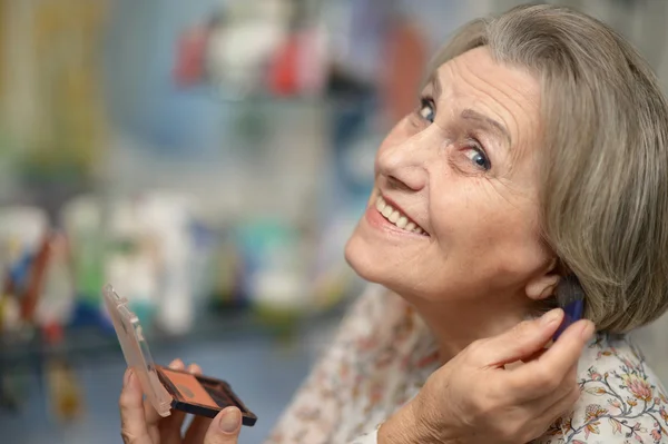 Senior woman doing make-up — Stock Photo, Image