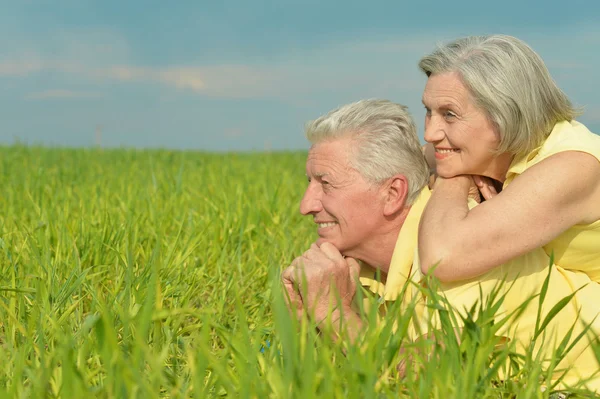 Old couple lying on the field — Stock Photo, Image