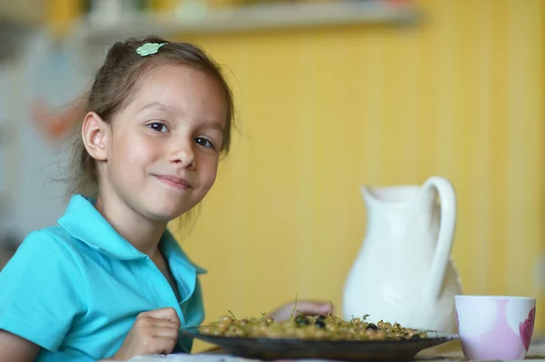 Klein meisje eten krenten — Stockfoto