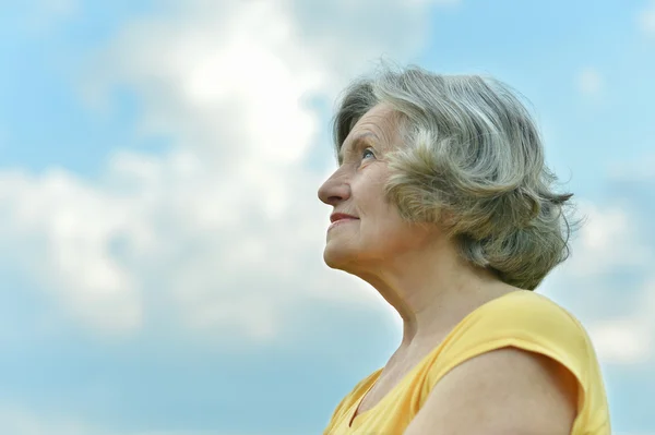 Mujer madura en el fondo del cielo — Foto de Stock