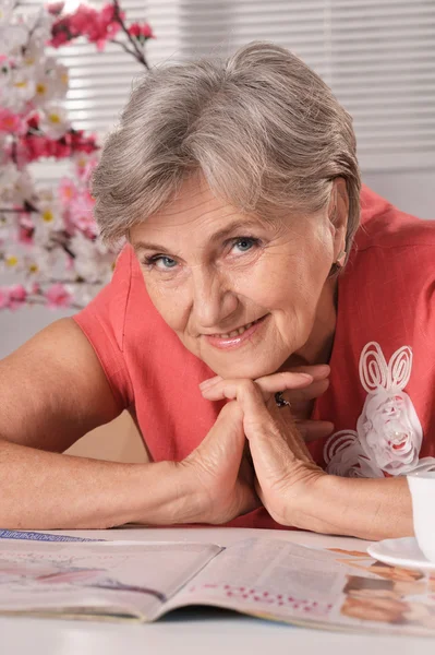 Middle-aged woman reading magazine — Stock Photo, Image