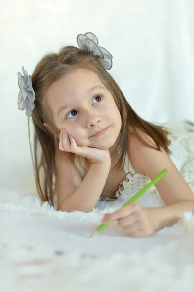 Jeune fille avec un crayon au lit — Photo