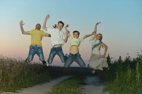 Familie springen in veld — Stockfoto