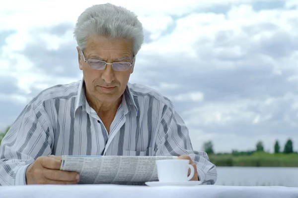 Older man reading newspaper — Stock Photo, Image