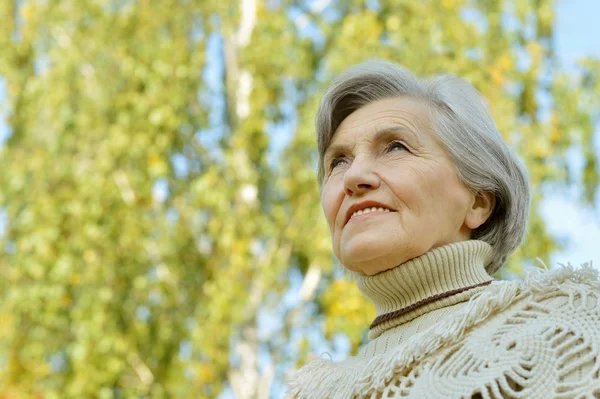 Elderly woman in autumn park — Stock Photo, Image