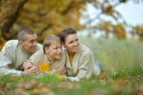 Familie liggen in de herfst park — Stockfoto