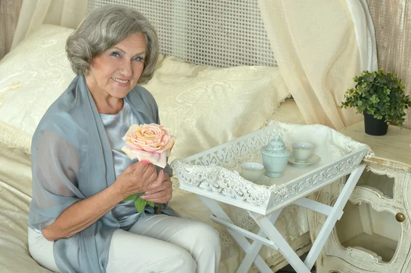 Mujer mayor con flor — Foto de Stock