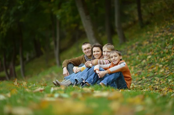 Familia sentada en el parque de otoño — Foto de Stock