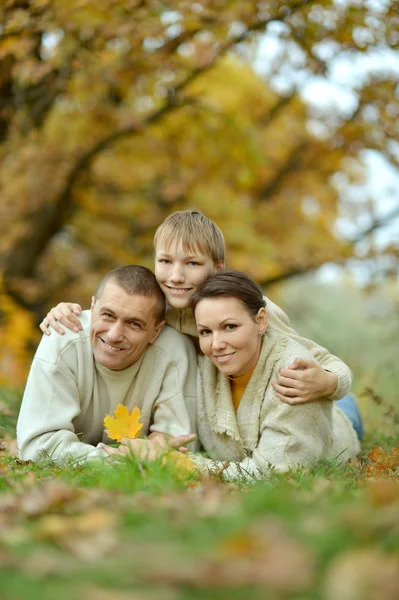 Familie liggen in de herfst park — Stockfoto