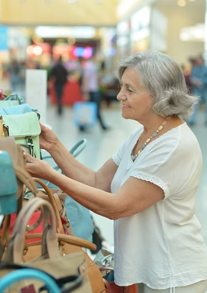 Lachende oude dame in winkel — Stockfoto