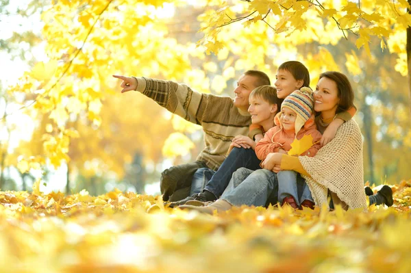 Familia sentada en el parque de otoño — Foto de Stock