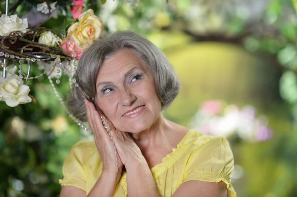 Elderly woman in summer garden — Stock Photo, Image