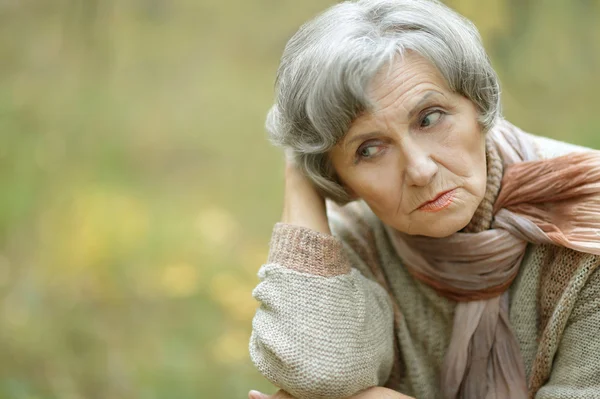 Sad old woman in autumn — Stock Photo, Image