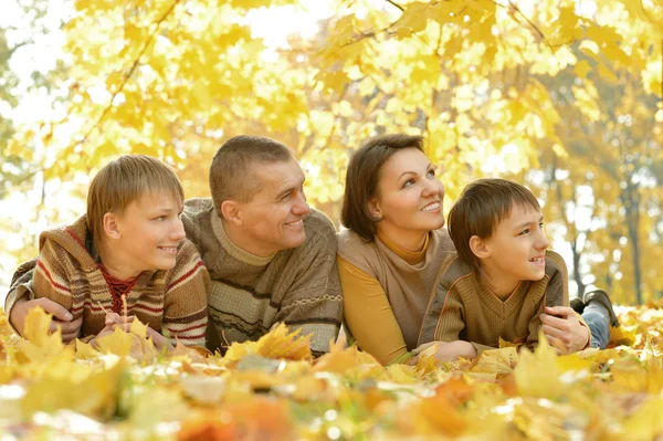 Family lying in autumn park — Stock Photo, Image