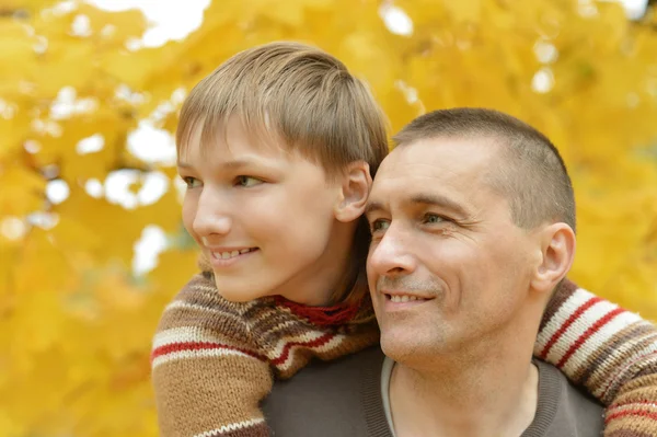 Vader en zoon in herfst park — Stockfoto