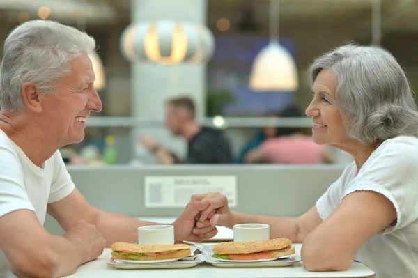 Elderly couple eating fast food — Stock Photo, Image