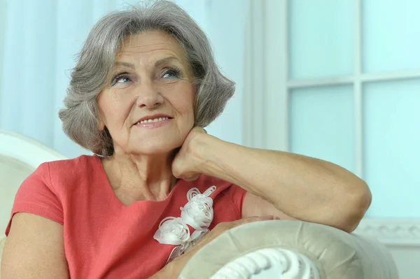 Reife Frau sitzt auf Sofa — Stockfoto