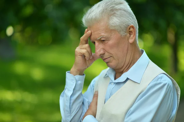 Uomo anziano serio che pensa nel parco — Foto Stock