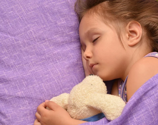 Kleines Mädchen schläft mit einem Spielzeug — Stockfoto