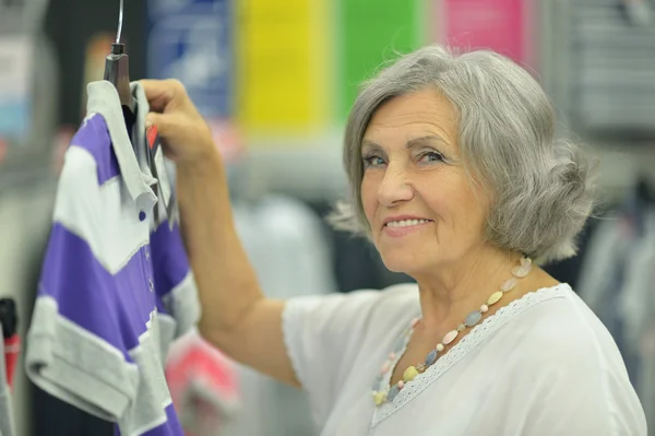 Lachende oude dame in winkel — Stockfoto