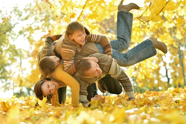 Family lying in autumn park — Stock Photo, Image