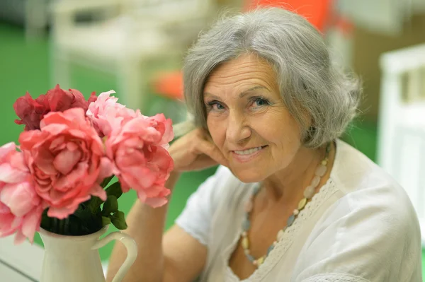 Ältere Frau mit Blumen — Stockfoto