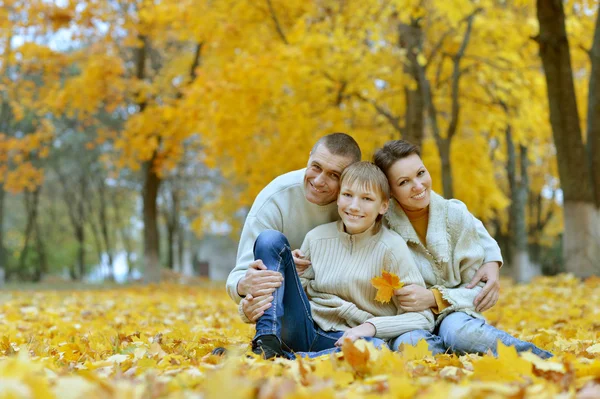 Rodina sedí v podzimním parku — Stock fotografie