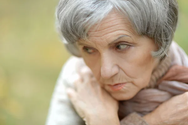 Trist gammel dame om høsten – stockfoto