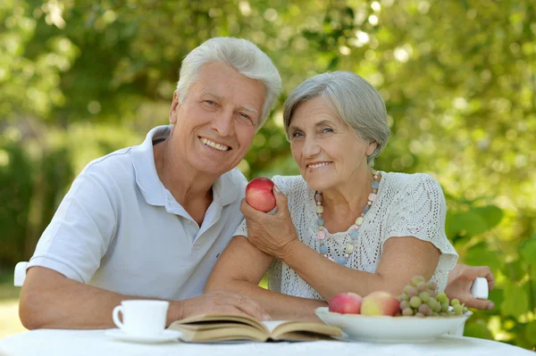 Old couple with fruits ans drink Stock Picture