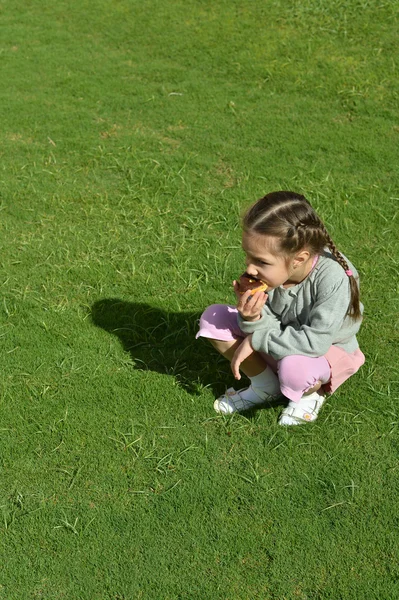 Klein meisje donut eten — Stockfoto