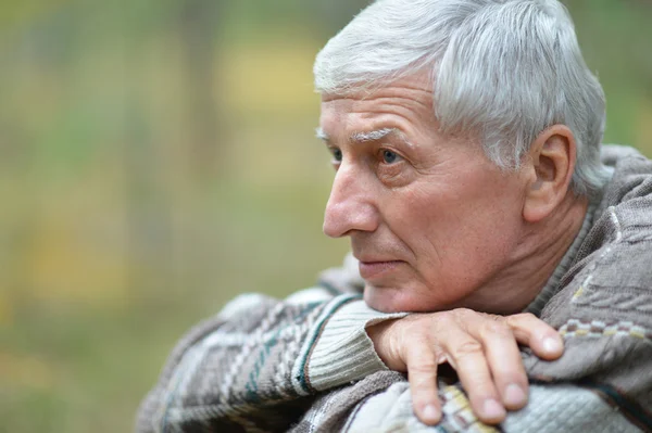 Задумчивый пожилой человек осенью — стоковое фото