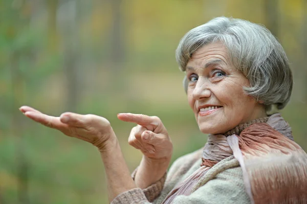 Seniorin zeigt in Park — Stockfoto