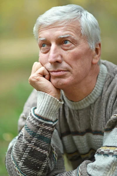 Thoughtful elderly man in autumn — Stock Photo, Image