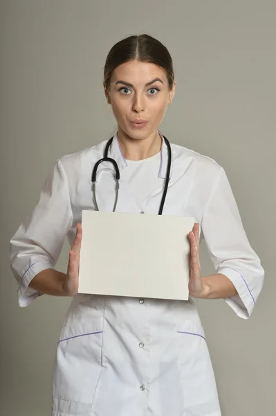 Vrouwelijke arts met witte lijst — Stockfoto