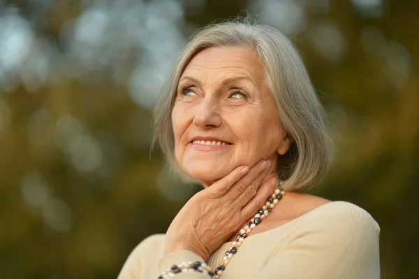 Senior woman in autumn park — Stock Photo, Image