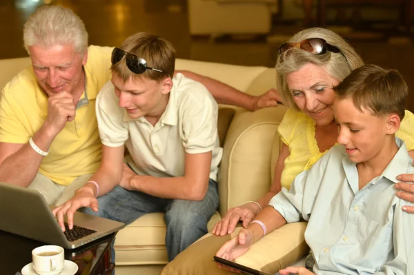 Familie sitzt mit Laptop — Stockfoto