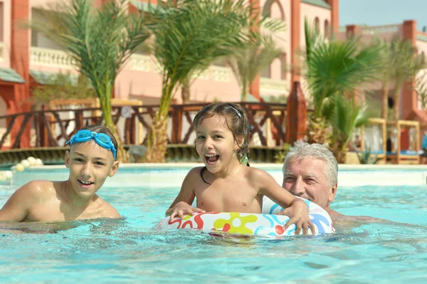 Nonno con nipoti in piscina — Foto Stock