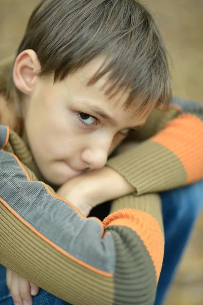 Маленький грустный мальчик в парке — стоковое фото