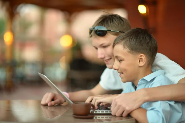 Brothers with laptop at table — Stock Photo, Image