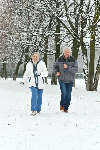 Äldre par kör på vintern — Stockfoto