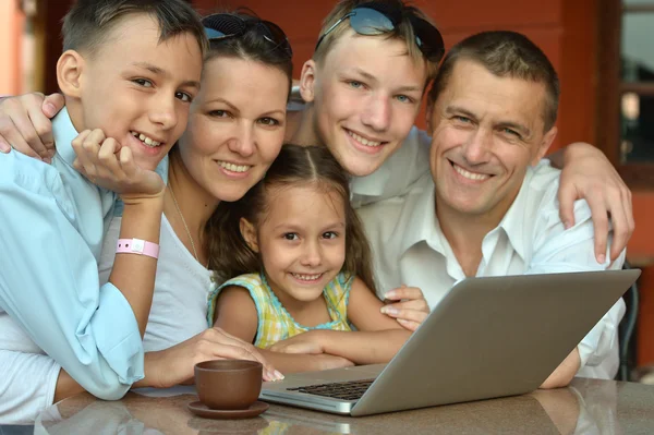 Famiglia seduta con computer portatile — Foto Stock