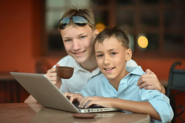 Brothers with laptop at table — Stock Photo, Image