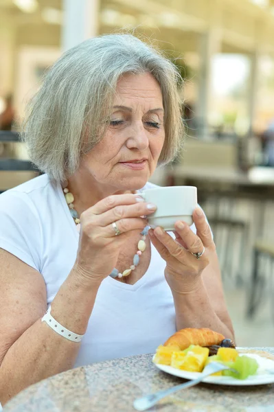 Mooie bejaarde vrouw in café — Stockfoto